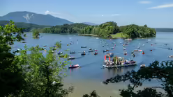 Teilnehmer einer Fronleichnam-Prozession fahren in geschm&uuml;ckten Booten &uuml;ber den Staffelsee zur Pfarrkirche auf der Insel W&ouml;rth / &copy; Matthias Balk (dpa)