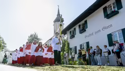Teilnehmer einer Fronleichnam-Prozession ziehen von der Pfarrkirche St. Michael zu einer Boots-Anlegestelle am Staffelsee / &copy; Matthias Balk (dpa)
