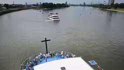 Teilnehmer sitzen bei der "M&uuml;lheimer Gottestracht" auf dem Deck des F&uuml;hrungsschiffes "Rhein Fantasie" / &copy; Ina Fassbender (dpa)