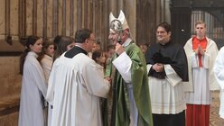 Weihbischof Dr. Dominikus Schwaderlapp gratuliert Chorleiter Oliver Sperling nach dem Pontifikalamt, das auch in Erinnerung an den Bischofsweihetag von Kardinal Höffner gefeiert wurde. / © Beatrice Tomasetti (DR)