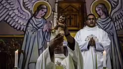 Weihnachten in Gaza:  Ein Priester hält eine Figur des Jesu-Kindes bei einer Heiligabend-Messe.  / © Ahmad Hasaballah (dpa)