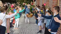 Zum Abschied ihrer beliebten Schulleiterin bilden alle Kinder ein Rosenspalier f&uuml;r Gertrud Trebels / &copy; Beatrice Tomasetti (DR)